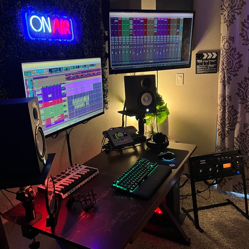 Studio desk with dual monitors, MIDI keyboard and Apollo interface